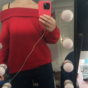 Röd offshoulder stickad tröja - Säljer en röd stickad tröja med bred offshoulder-ringning och långa ärmar. Tröjan har en ribbad kant upptill som ger en snygg och chill look. Perfekt för dig som gillar att sticka ut med färg och vill ha något mjukt och bekvämt. Jätte söt tröja som jag använt till julafton och liknade som inte kommer till min användning längre 😅 sjätte skön och vacker ☺️🥰 Använt 3 gånger ‼️☺️