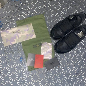 Valentino Garavani svarta sneakers - Svarta Valentino Garavani sneakers med coolt camouflagemönster och detaljer i både skinn. Kan gå ner i pris vid snabbaäffär andvönda 12gånger