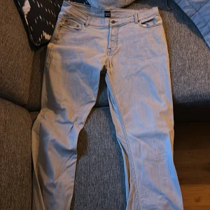 Ljusgrå jeans från Montén 34/34 - Snygga ljusgrå jeans från Montén i klassisk femficksmodell med knappstängning och läderpatch bak. Jeansen har rak passform och är tillverkade i mjukt bomullsmaterial. Perfekt för dig som gillar stilrena och enkla jeans.
