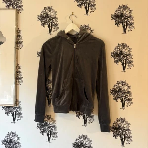 Grå velour hoodie från Gina Tricot - Mjuk och skön grå hoodie i velour från Gina Tricot. Tröjan har dragkedja framtill, huva med metallöglor och två fickor. Långärmad modell med breda muddar vid ärmslut och nederkant. Perfekt för chill dagar och snygg att matcha med jeans. Snörerna saknas!🥰❤️