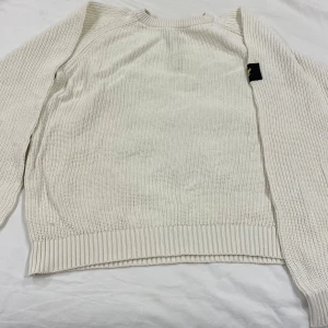 Vit stickad tröja Lyle & Scott Junior - Säljer en vit stickad tröja från Lyle & Scott Junior med klassisk rund hals och ribbade muddar. Tröjan har lång ärm och en svart patch med gul fågel på ena ärmen. Perfekt för dig som gillar enkel och stilren design. PRISET KAN DISKUTERAS 