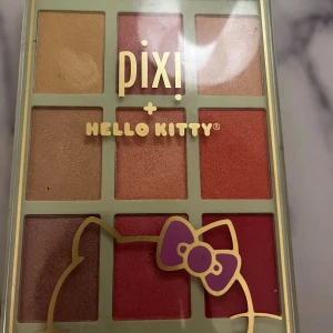Pixi x Hello Kitty Chrome Glow Palette - Superfin ögonskuggspalett från Pixi i samarbete med Hello Kitty. Paletten innehåller nio skimrande nyanser i guld, rosa, röd och brons. Perfekt för att skapa både mjuka och färgstarka looks. Söt design med Hello Kitty-detaljer på locket. Nypris 300