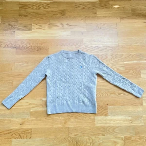 Morris kabelstickad tröja - Fin och elegant Beige Morris kabelstickad tröja med blå emblem i storlek XXS, sitter lite tajtare än andra Morris tröjor. Pris kan diskuteras.