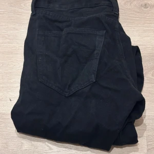 Svarta Levi's 501 jeans W32 L32 - Svarta Levi's 501 jeans med klassisk rak passform och fem fickor. Jeansen har en snygg svart färg och är tillverkade i slitstarkt bomullsmaterial. Perfekt för dig som gillar tidlös stil och vill ha ett par jeans som funkar till allt.