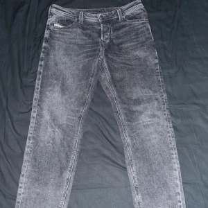Diesel Larkee-Beex grå jeans 31/32 - Säljer ett par gråa Diesel Larkee-Beex jeans i storlek 31/32. De har en klassisk femficksdesign, raka ben och en snygg tvättad finish. Jeansen är tillverkade i slitstarkt denim och har en normal passform som sitter skönt hela dagen.