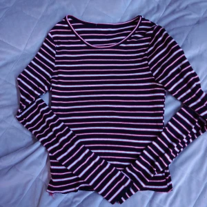 Randig långärmad topp. - En långärmad topp med rränder i svart, vit och röd.