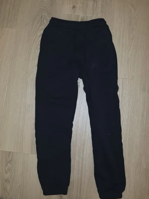 Svarta mjukisbyxor från Take Off/ storleken är 146/152 - Svarta mjukisbyxor från Take Off med dragsko i midjan och muddar vid bensluten. Tillverkade i mjukt bomullsmaterial för maximal komfort. Perfekta för chill dagar eller när du vill ha det extra bekvämt. Dom är också ganska korta för storleken❤️ 