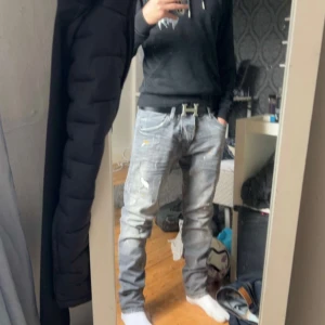 Cool Guy jeans med dq2 tecken - PRIS KAN DISKUTERAS… Säljer ett par grå jeans med Dq2  tecken men dom är för stora köpte fel storlek men med coola slitningar, färgstänk och retroinspirerad patch bak. Jeansen har en rak passform och klassisk femficksdesign. Perfekta för dig som gillar streetstyle och vill sticka ut med detaljer.