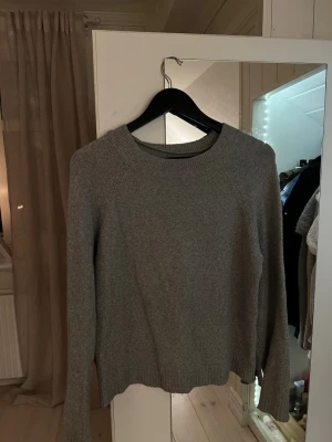 Grå stickad tröja från Vero Moda - Säljer en grå stickad tröja från Vero Moda i storlek XS. Tröjan har rund hals, långa ärmar och ribbade muddar vid hals, ärmslut och nederkant. Tecken på användning men inga defekter. Den är lite uttänd i ärmar och hals 