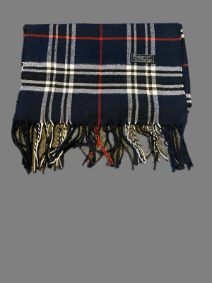Rutig Burberrys scarf i lammull - Säljer en klassisk rutig scarf från Burberrys i mörkblått, vitt och rött. Scarfen är tillverkad i 100% lammull och har fransar längs nederkanten. Perfekt för dig som gillar tidlös design och vill ha något som sticker ut lite extra. Perfekt nu när snön har kommit❄️ Kom med frågor eller prisförslag!