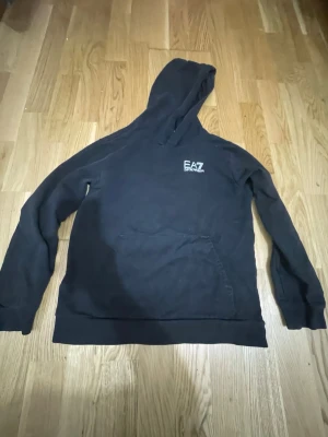 Svart Armani Hoodie  - Säljer en svart EA7 hoodie i storlek xs säljer för att den inte passar mig knappt använd och bra o ha för vardagligt bruk