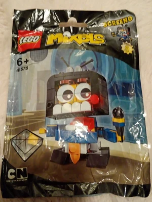 LEGO Mixels Screeno 41578 - LEGO Mixels Screeno 41578 från serie 9, inspirerad av Cartoon Network. Byggfiguren har en cool design med stora ögon, svart och blå kropp, röda och gula detaljer samt en mikrofon. Perfekt för dig som gillar samlarfigurer och unika byggleksaker.