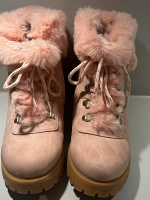 Rosa boots i storlek 38  med fluffig päls och snörning - Ljusrosa boots med grova sulor, perfekta vinterkängor. Aldrig använda. Kängorna är något små i storleken, dem passar mig som oftast har 37.