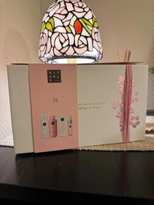 Rituals The Ritual of Sakura presentbox - Lyxig presentbox från Rituals med The Ritual of Sakura-serien. Innehåller duschskum, duscholja, body cream och body mist i rosa och vita förpackningar. Perfekt för dig som älskar fräscha och blommiga dofter. Kommer i en elegant vit och rosa box med blomdetaljer.