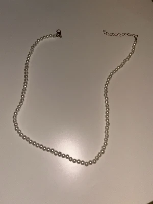 Pärlhalsband - Bilderna visar ett pärlhalsband med guldfärgat lås. Köpt från small business.🫰🏼