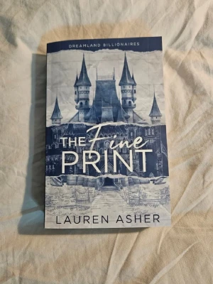 The Fine Print av Lauren Asher - Jag säljer denna moderna och populära booktok bok om drömmar och kärlek, där två unga vuxna möts i en värld av nöjesparker och sagoslott. Detta är första boken i Dreamland Billionaires serien av Lauren Asher. Perfekt för dig som gillar romantik, drama och att följa karaktärer som utmanar varandra och sig själva. Nypris runt 150 kr. I mycket bra skick, endast läst en gång. Jag älskade denna bok, och rekommenderar den verkligen. 