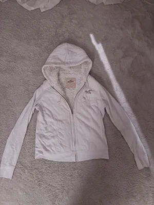 Vit zip up Hoodie Hollister fodrad  - Vit zip up Hoodie ifrån Hollister med vitt mjukt foder! Är k storlek L men passar M också 
