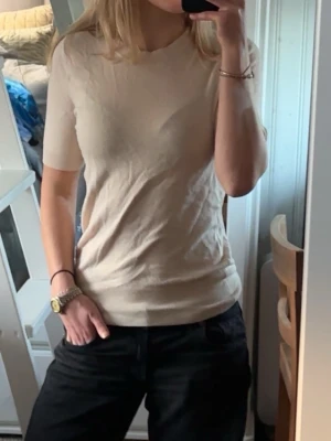 Beige t-shirt från Zara  - Säljer en stilren beige t-shirt från Zara i storlek S. T-shirten har korta ärmar och är gjord i mjuk bomull som känns skön mot huden. Enkel och clean design med rund halsringning, perfekt att matcha med jeans eller shorts.