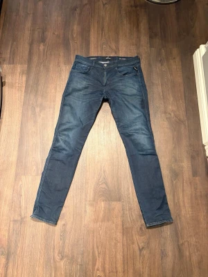 Replay Hyperflex Anbass jeans blå - Säljer ett par Replay Hyperflex Anbass jeans i mörkblå tvätt. Modellen har slim passform, klassisk femficksdesign och dragkedja i gylfen. Materialet är stretchigt jeans och midjan är midwaist. Perfekta för dig som gillar bekväma och snygga jeans.