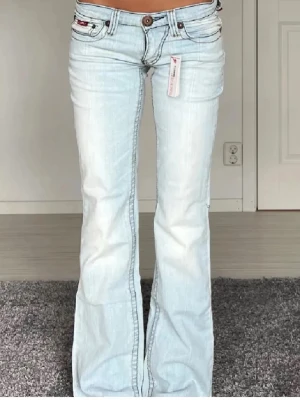 ljusblå bootcut jeans - Midjemåttet är 38 cm rakt över och innerbenslängden är 81 cm, prislapp sitter kvar