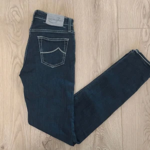 Jacob Cohën Jeans Mörkblå W28 - Exklusiva jeans från Jacob Cohën, handgjorda i Italien av japanskt premiumdenim. Mörkblå tvätt med kontrastsömmar och klassisk bakficka. Slim fit med hög komfort och tidlös design. Meddela om frågor eller pris😊