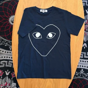 Mörkblå Comme des Garçons Play t-shirt - SKICKA PRISFÖRSLAG! Snygg mörkblå t-shirt från Comme des Garçons Play med det ikoniska hjärtmotivet i vitt på bröstet. Passar 165-175 cm
