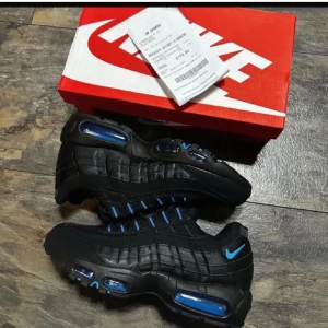 Nike Air Max 95 Svart/Blå  - Nike Air Max 95 Svart/Blå – Storlek 43 – Nytt skick: Säljer ett par Nike Air Max 95 i svart med blå detaljer, storlek 43. Skorna är i nytt skick. 