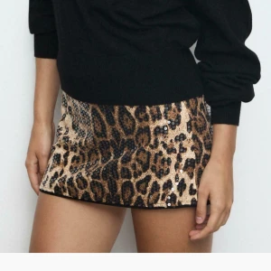 Leopardmönstrad paljettkjol - Säljer en kort kjol med leopardmönster och glittriga paljetter. Kjolen har en rak och tight passform, med beige och bruna toner som kombineras med svarta detaljer. Det finns inbyggda shorts i kjolen!💕 endast använd 1 gång!! Nypris är 300kr därav priset 🩷