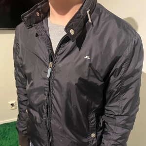 Svart jacka från J.Lindeberg - Snygg svart jacka från J.Lindeberg med diskret logga på bröstet. Jackan är i väldig fint skick och är i storlek S, Small. 