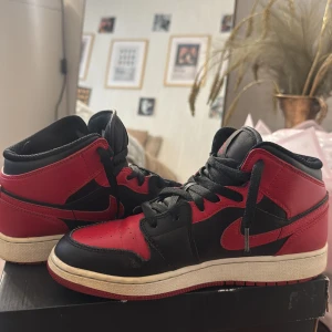 Nike Air Jordan 1 Mid Svart/Röd - Säljer ett par Nike Air Jordan 1 Mid i klassisk svart och röd färg. Dem har används men fortfarande i bra skick. 