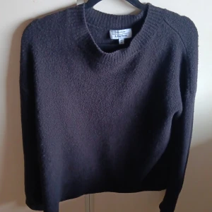 Svart stickad tröja & Other Stories - Mysig svart stickad tröja från & Other Stories med rund halsringning och lång ärm. Perfekt för lager-på-lager och enkel att styla till jeans eller kjol. Tjockt, strukturerat material som håller dig varm under kyliga dagar.