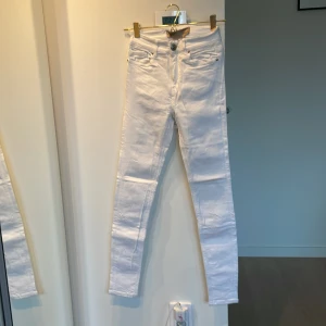Vita skinny jeans | Mila Marsel - Snygga vita skinny jeans från Mila Marsel med hög midja. Jeansen är i stretchigt bomullsmaterial och har silverfärgade detaljer med logga på knappen. Mycket gott skick och helt fläckfria! 🤍