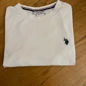 T-shirt - Klassisk vit t-shirt från U.S. Polo .T-shirten är i mjuk bomull och har korta ärmar. Perfekt basic-plagg med stilren look och diskreta detaljer.