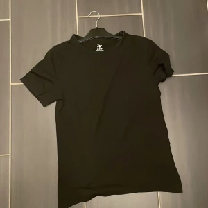 Svart t-shirt från ICA I Love Eco - En stilren svart t-shirt från ICA I Love Eco i ekologisk bomull. Klassisk rund halsringning och korta ärmar. Perfekt basic-plagg med skön passform och mjukt material.