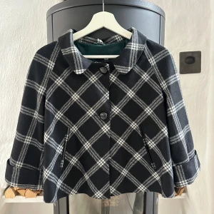 Rutig svart kappa från H&M, strl 38 - Snygg kort kappa från H&M i svart med vitt rutmönster. Skulle påstå att den är så gott som ny, hade bara behövts rollas lite🫶 Så så snygg nu till hösten😍 Jag bär vanligtvis 34/36 och på mig sitter den bra!💕