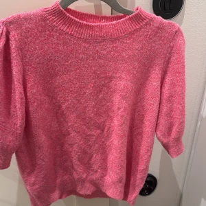 Rosa stickad tröja med halvlånga ärmar - Superfin rosa stickad tröja med halvlånga ärmar och ribbad rund halsringning. Perfekt för dig som vill ha en mysig och färgglad look. Passar lika bra till jeans som till kjol.