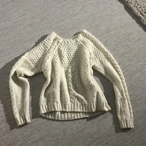 Vit stickad tröja med flätmönster - Säljer en vit stickad tröja med snygga flätade detaljer. Perfekt för hösten och vintern, knappt använd