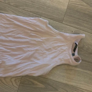 Ljusrosa ribbstickad linne  - Säljer en ljusrosa ribbad linne från Vero Moda. Linnet har en rund halsringning och har en tight passform. Perfekt för sommardagar eller bara en fin outfit hemma. Enkel att matcha med jeans eller kjol.