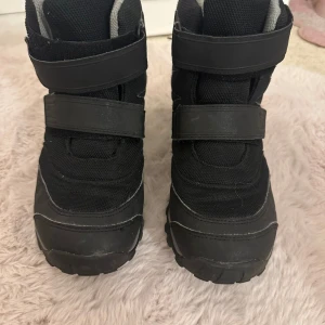 Svarta vinterkängor från Viking - Svarta vinterkängor från Viking med grå detaljer och grov sula för bra grepp. Kardborreband gör dem enkla att ta på och av. Ovandel i slitstark textil och syntet, fodrade för extra värme. Perfekta för kalla dagar och snö. Är lite noppriga!!