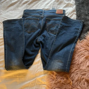 Levi's 315 Shaping Bootcut Jeans blå - Säljer ett par Levi's 315 Shaping Bootcut jeans i klassisk blå tvätt. Jeansen har bootcut-ben, femficksmodell och snygga slitningar framtill. De är tillverkade i stretchig denim för extra komfort och har normal passform med medelhög midja. Säljer då dom ej används, har använt dom endast en gång. Pris går att diskutera💞