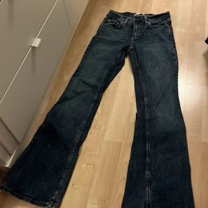 Blå Lågmidjade bootcut jeans - Blå lågmidjade/mid jeans ifrån GinaTricot. De är bootcut/flare. Midjemått: 32cm Innerbenslängd: 76cm.  De är endast använda ett fåtal gånger och är i mycket bra skick, nypris: 499kr