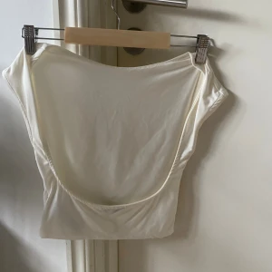 Vit  topp med öppen rygg från Bershka - Säljer en jätte snygg topp med öppen rygg från bershka då den tyvärr är för liten för mig 