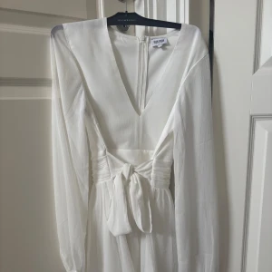 Vit omlottklänning från Bubbleroom - Supersnygg vit kortklänning från Bubbleroom med v-ringning. Använd endast en gång på student. Skriv för fler bilder💕