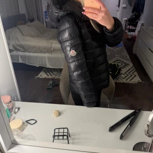 Svart Moncler jacka - Säljer snyggaste moncler jackan i modellen bady som är snarlik Maya modellen. Jackan är använd använd 2 vintrar, och har inga defekter förutom att kalla anka bilden lossnat lite. Säljer den eftersom jag har en ny vinterjacka. Jag bär normalt xs/s och är 165, denna är för 14 år och passar mig perfekt! ❄️❄️❄️