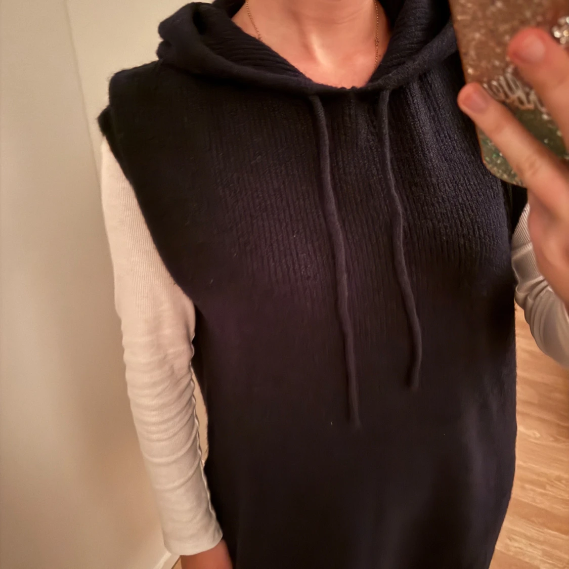 Stickad ärmlös tröja med luva