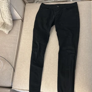 Svarta byxor från Emporio Armani - Svarta byxor från Emporio Armani i klassisk femficksmodell. Byxorna har smal passform och är tillverkade i ett mjukt bomullsmaterial med stretch. Snygg och stilren look med diskret logga vid fickan. Perfekta för dig som gillar en clean och modern stil.