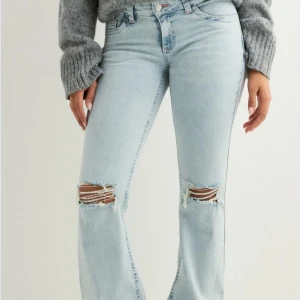 Nelly jeans med slitningar - Snygga ljusblå jeans från Nelly med bootcut passform och slitna detaljer. Dom är i nyskick. Jag är 160lång och dom passar mig perfekt. Pris kan diskuteras 