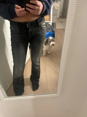 Bootcut svarta jeans från Bershka - Säljer ett par svarta bootcut jeans från Bershka med två knappar i midjan och klassisk femficksdesign. Jeansen har en lätt tvättad look och är tillverkade i jeansmaterial. Perfekt för dig som gillar en lite vidare passform nertill. Jag med storlek 158 kan ha dem.