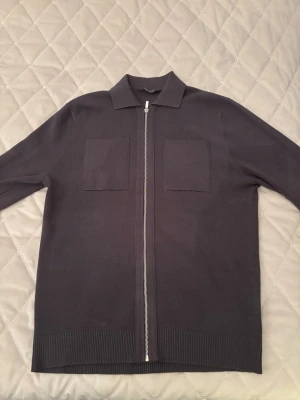 Grön fullzip tröja - Snygg grön fullzip tröja från primark med stilren design, två stora bröstfickor och hel dragkedja framtill. Tröjan har klassisk krage och ribbade muddar vid nederkant. Aldrig använd