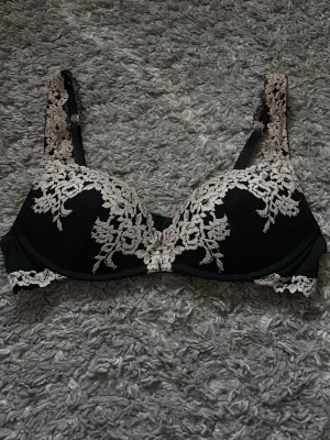 Svart Intimissimi bh med vit spets - Snygg svart bh med vita broderade spetsdetaljer framtill och på axelbanden. Storleken är 80B, bara använd en gång 